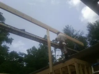 Carpenter setting a ridge beam over a new addition frame — Ice Dam Removal by Roofing Brothers in Rupert